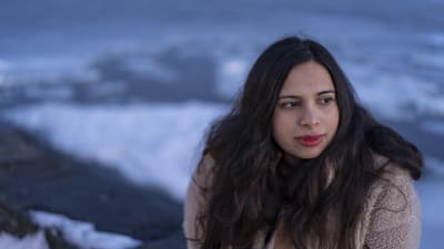 Vakavailmeinen nainen taustanaan jäätynyt meri