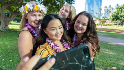 Havaijin au pairit ottavat ryhmäselfietä puhelimella