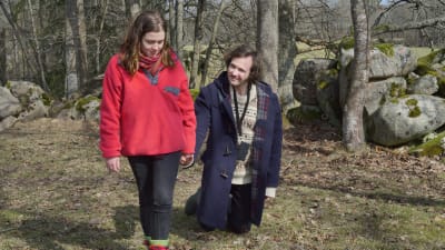 Melissa (Amy Deasismont) går hand i hand med Gösta (Vilhelm Blomgren) som går på knäna ute på en äng.