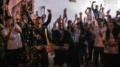 Firande oppositionsanhängare öppnar en champagneflaska utanför en vallokal i Hongkong