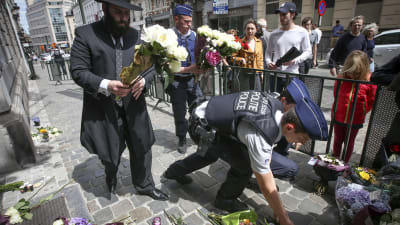 Blommor läggs vid judiska museet i Bryssel där tre personer sköts ihjäl den 24 maj 2014.