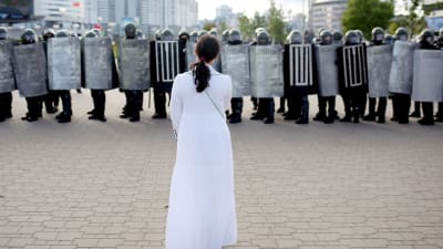 Kvinna som ställer sig emot polisen under en demonstration i Minsk