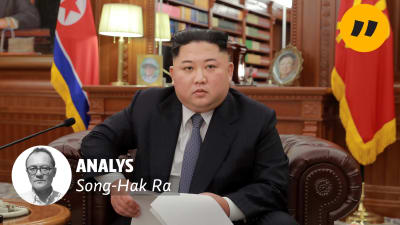 Kim Jong-Un sitter med en pappersbunt i handen.