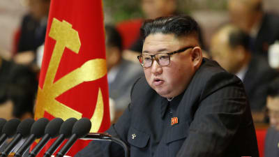 Nordkoreas ledare Kim Jong-Un talar. I Bakgrunden syns Nordkoreas flagga