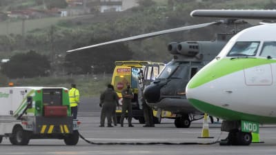 Ambulanssi, helikopteri ja lentokone lentokentällä.
