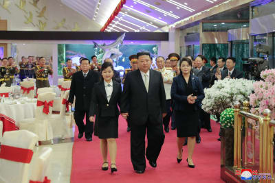 Nordkoreas ledare Kim Jong-Un går i mitten med sin dotter Kim Ju-Ae och sin fru Ri Sol-Ju under en galamiddag i Pyongyang.