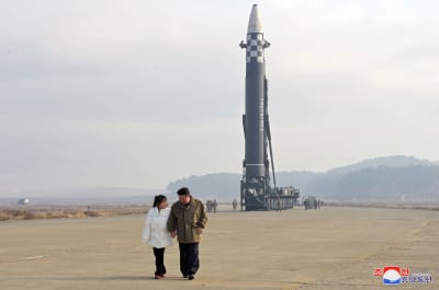 Nordkoreas ledare Kim Jong-Un går framför en interkontinental robot på Pyongyangs internationella flygplats med sin dotter Kim Ju-Ae på hösten år 2022.