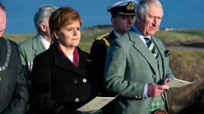 Prins Charles och Skottlands förstaminister Nicola Sturgeon ser allvarliga ut vid en utomhusceremoni. Charles är klädd i kilt.