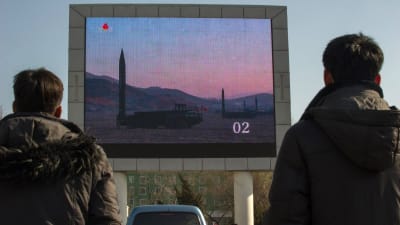Nordkoreaner tittar på nyhetsinslag om missiltestet den 7.3. på en stor skärm på järnvägsstationen i Pyongyang.