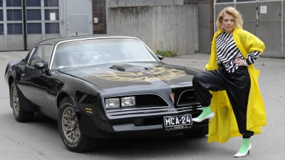 Susanna Vainiola seisoo vuoden 1978 mallisen Pontiac Trans Amin edessä.