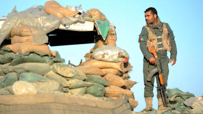 En soldat står vid sandsäckar vid en postering i Nangahaar kort efter ett dödligt angrepp i området.