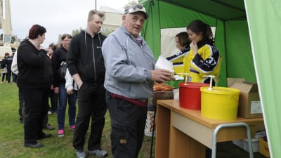 Korvförsäljning  på Parhalahtidagen i Pyhäjoki, man med korv i handen
