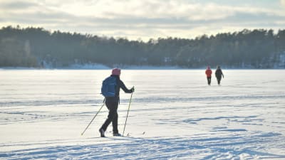 Människor som skidar och går på is med snö på.