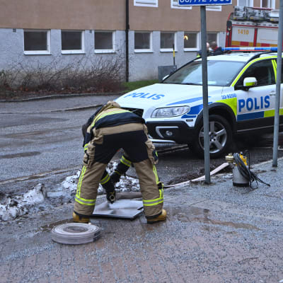 Två poliser i Stockholm undersöker en gata där det förekommit skottlossning.  