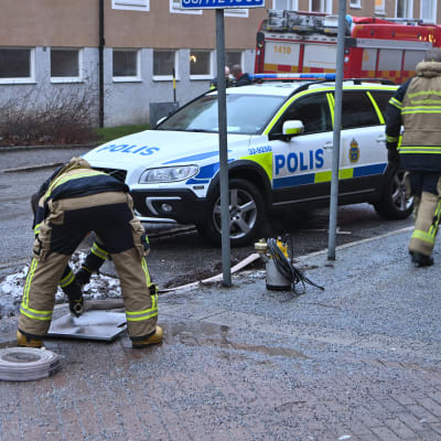Två poliser undersöker en plats där det avfyrats skott i Bagarmossen i Stockholm.