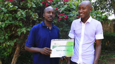 Två kongolesiska flyktingar som lärt sig engelska på flyktinghjälpens kurs.