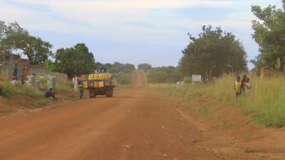 en bil levererar gin i gula plastdunkar i norra uganda