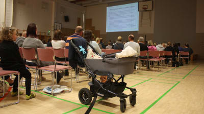 Publik med barnvagn i förgrunden.