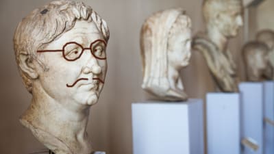 Grekisk staty med efteråt ritade glasögon och mustasch