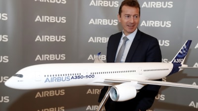 Airbus vd Guillaume Faury står bredvid en modell av ett Airbus A350-900-plan