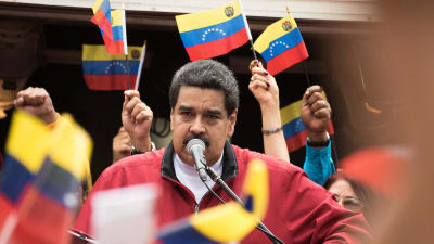 Venezuelas president Nicolas Maduro håller tal. Han är omgiven av landets flaggor.