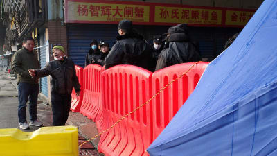 En avspärrning på en kinesisk marknad. Gatan är avspärrad med stora röda hinder. 