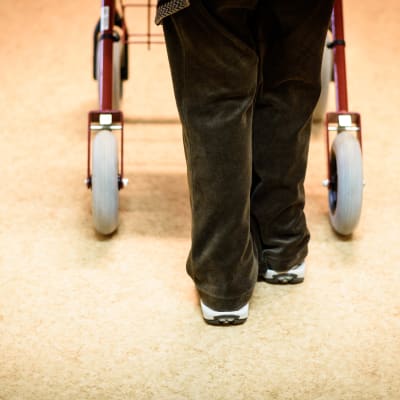 Fötter som går med rollator.