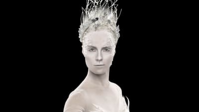 En kvinna med vitt smink med en krona på huvudet.