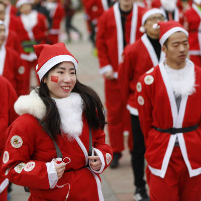 Invånare i Peking utklädda till julgubben värmer upp för Santa Claus fun run (ungefär julgubbsloppet). Bilden från 22 december 2018.