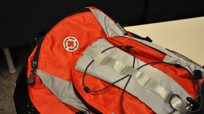 En röd och grå ryggsäck med Röda korsets logotyp.
