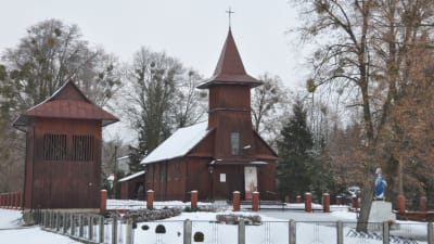 Katolsk kyrka i vinterlandskap i Polen