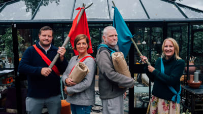Micke Björklund, Maria Sundblom Lindberg, Pata Degerman och Sofia Torvalds står på rad som två Robinson-lag med en röd respektive blå flagga fastknutna på käppar.