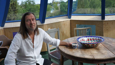 Jan-Erik Andersson sitter i torndelen i sitt Bladhus. Genom fönstren skymtar Åbo slott.