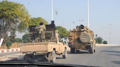 Två militärfordon på en asfalterad väg i Syrien.