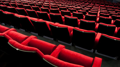 Röda stolar i en teater- eller biosalong.