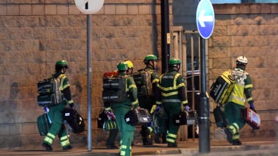 Räddningsmanskap går med utrustning i Manchester.