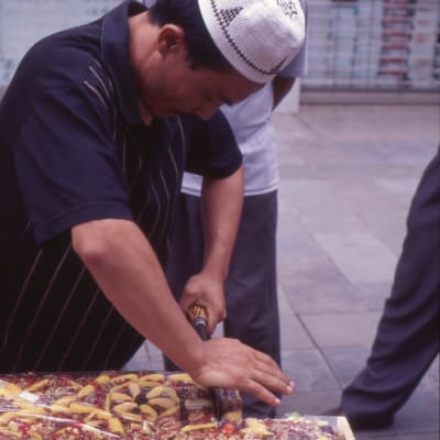 En uigur i Kina som säljer kakor