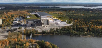 En flygbild över ett industriområde. Runt industriområdet finns skog och hav.