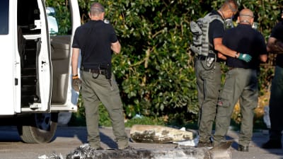 Ett israeliskt bombteam inspekterar resterna efter en palestinsk raket i kibbuzen Yad Mordechai i södra Israel på lördagen. 