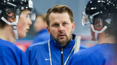 Antti Pennanen tittar allvarligt mellan två spelare.