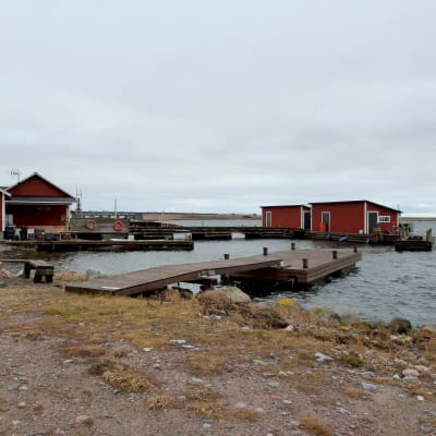 röda båthus vid en stenig hamn