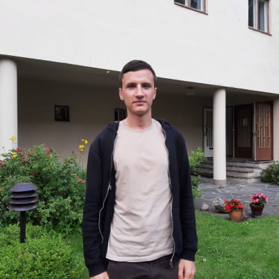 Man med t-skjorta och munktröja utomhus.