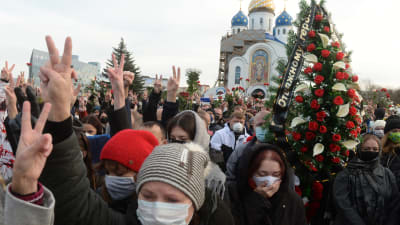 Människor som samlades till minnesceremonin för Bondarenko i fredags bar på blommor och visade segertecknet. 