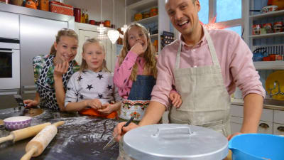 Programledarna Hanna Enlund och Jontti Granbacka bakar pepparkakor med flickorna Tuva och Joanna.