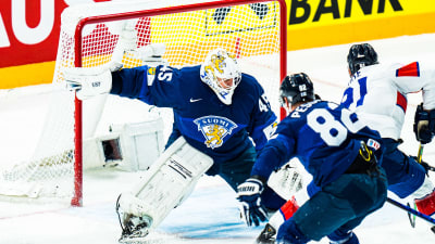 Hockeymålvakt med två spelare framför sig.