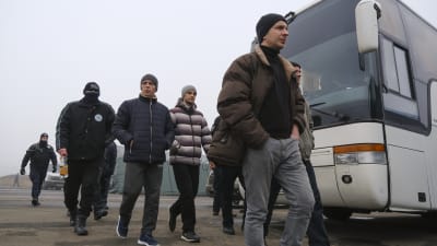 Fångar gick mot sina bussar vid Majorsk på söndagen. De flesta var inte bekymrade över att bli identifierade, men en del av dem täckte sina ansikten. 