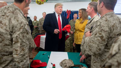 President Donald Trump delade ut kampankepsar under sitt besök på den amerikanska al-Asad-flygbasen i Irak.