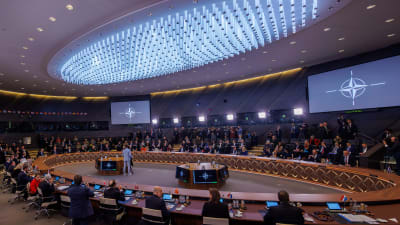Bild från Natos mötesutrymme med ett stort ovalt konferensbord för delegationernas representanter