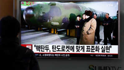 En sydkorean tittar på tv-nyheter i Seoul den 9 mars 2016. I nyhetssändningen figurerar Nordkoreas ledare Kim  JOng-un tillsammans med en missil.
