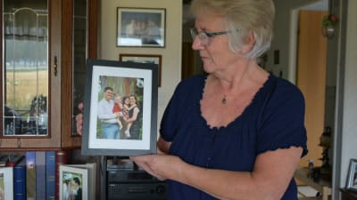 Gunborg Blom med ett fotografi av dottern Ellinor med familj som bor i Florida.